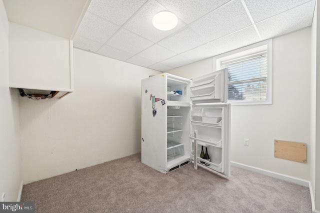 unfurnished bedroom featuring light colored carpet and a drop ceiling