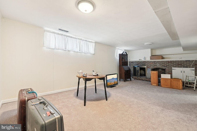 recreation room with brick wall, light carpet, and a fireplace