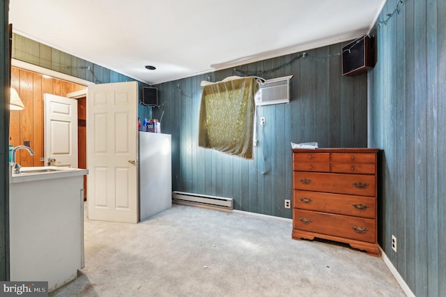 carpeted bedroom featuring a baseboard radiator, sink, a wall unit AC, and wooden walls