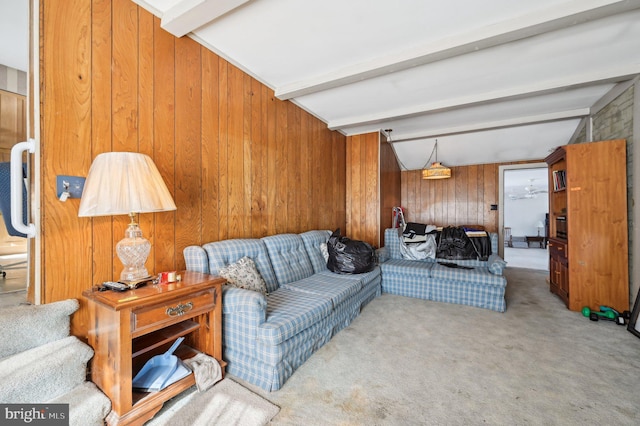 living room with lofted ceiling with beams, light carpet, and wood walls