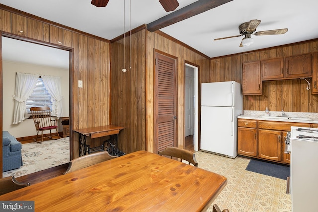 kitchen featuring ceiling fan, white appliances, crown molding, and wood walls