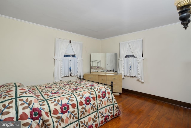 bedroom with dark hardwood / wood-style flooring and crown molding