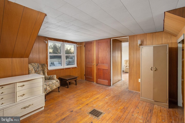 living area featuring wooden walls and light hardwood / wood-style floors