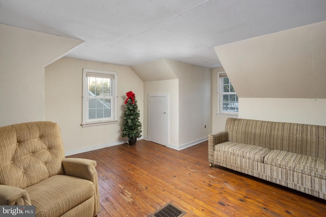 living area featuring vaulted ceiling and hardwood / wood-style floors