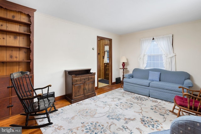 living room featuring ornamental molding and light hardwood / wood-style flooring