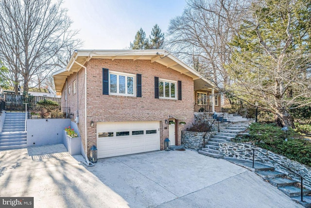 view of front facade featuring stairs, driveway, brick siding, and an attached garage