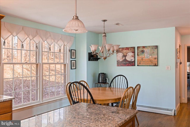 dining room featuring hardwood / wood-style flooring, a baseboard radiator, and a chandelier