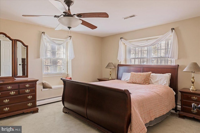 bedroom with ceiling fan, light colored carpet, and a baseboard heating unit