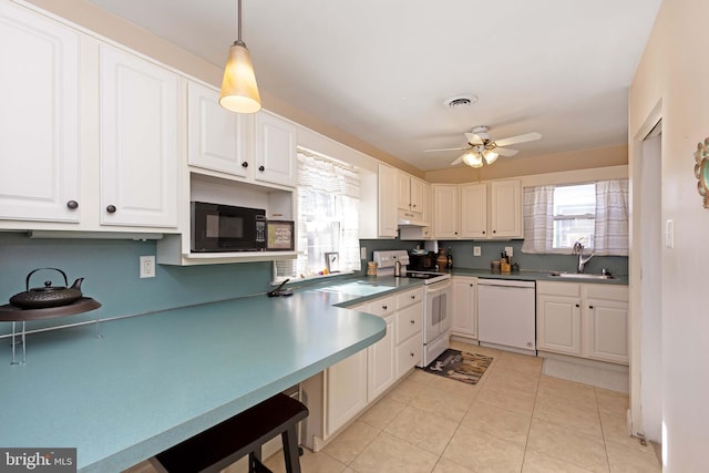 kitchen featuring white cabinetry, sink, white appliances, and hanging light fixtures