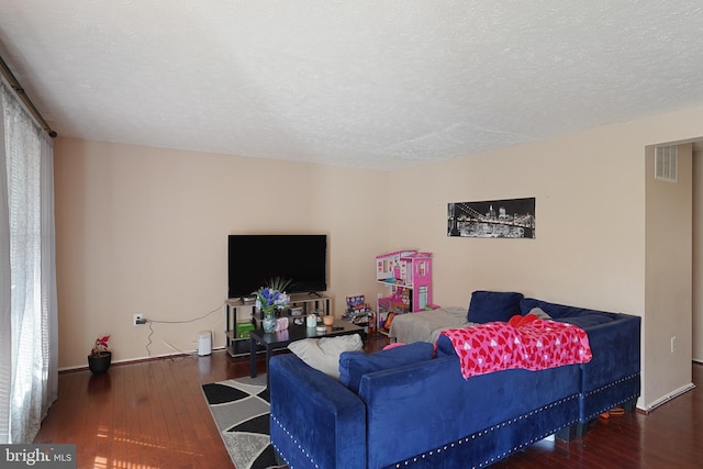 living room with dark hardwood / wood-style floors and a textured ceiling