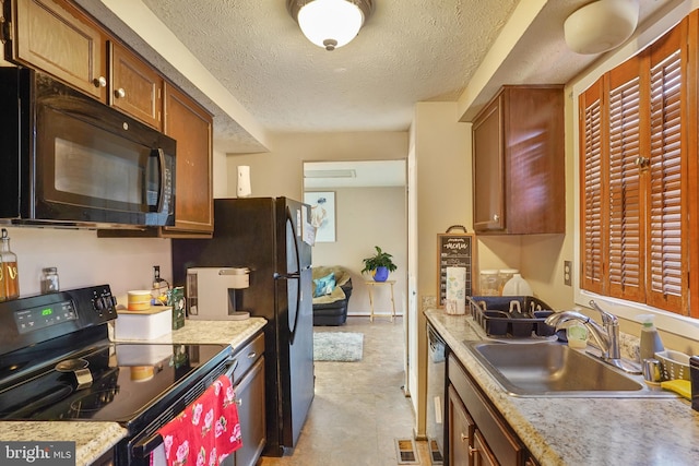 kitchen featuring sink, black appliances, a textured ceiling, and light stone countertops