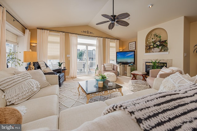 living room with lofted ceiling, a premium fireplace, and ceiling fan