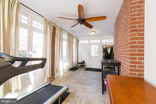 workout area featuring crown molding and brick wall