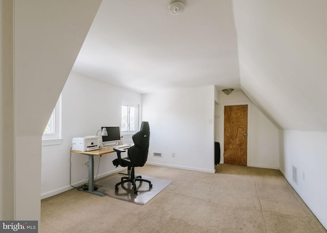 carpeted office with lofted ceiling and a healthy amount of sunlight