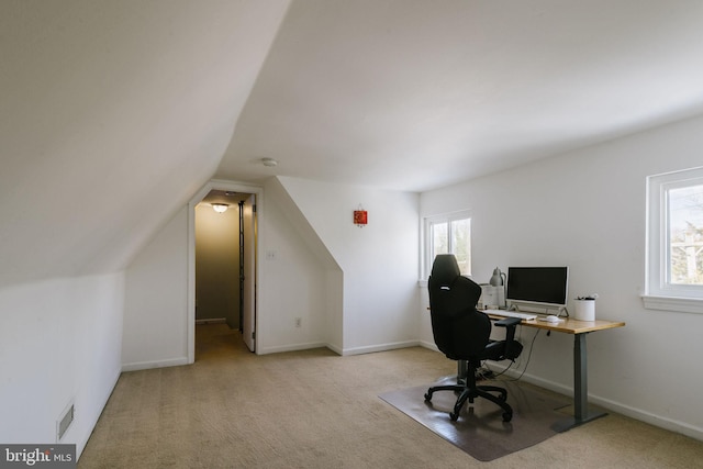 carpeted home office featuring vaulted ceiling