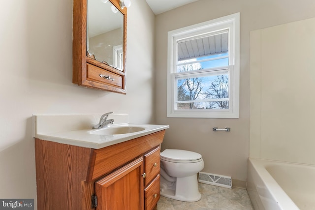 bathroom featuring vanity, tile patterned flooring, a washtub, and toilet