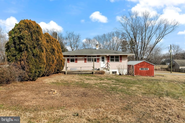 view of front of home with a storage unit and a front lawn