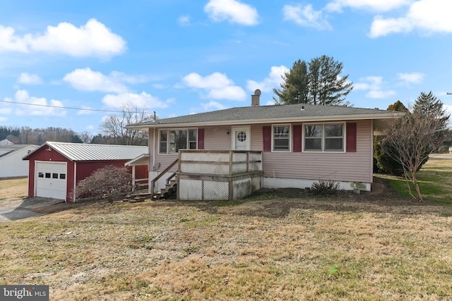 view of front of house with a garage, an outdoor structure, and a front yard