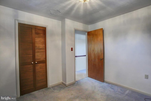 unfurnished bedroom featuring carpet flooring and a closet