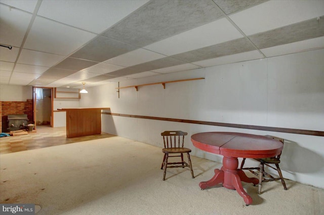 living area with carpet and a paneled ceiling