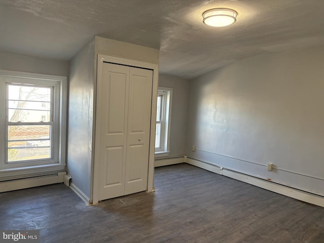 unfurnished bedroom featuring multiple windows, dark hardwood / wood-style floors, vaulted ceiling, and a closet