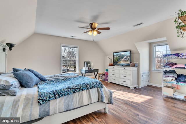 bedroom featuring multiple windows, hardwood / wood-style flooring, lofted ceiling, and ceiling fan