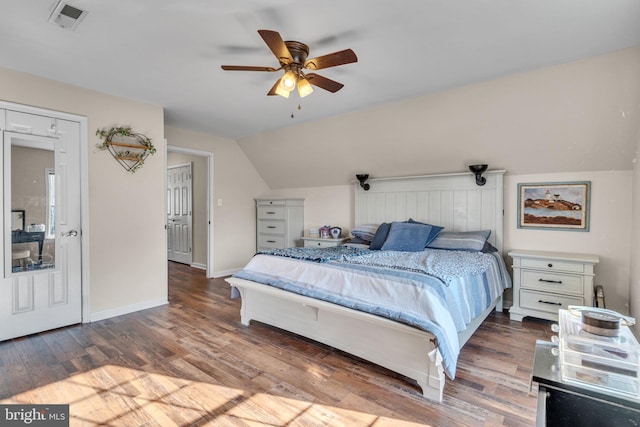 bedroom featuring dark hardwood / wood-style flooring, vaulted ceiling, and ceiling fan