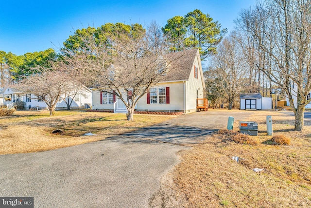 view of front of property featuring a shed and a front yard