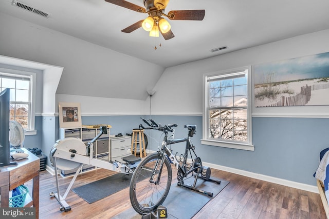 workout room featuring hardwood / wood-style flooring, vaulted ceiling, and ceiling fan