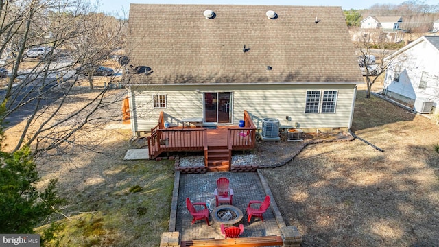 back of house with a yard, a deck, central AC unit, and a fire pit