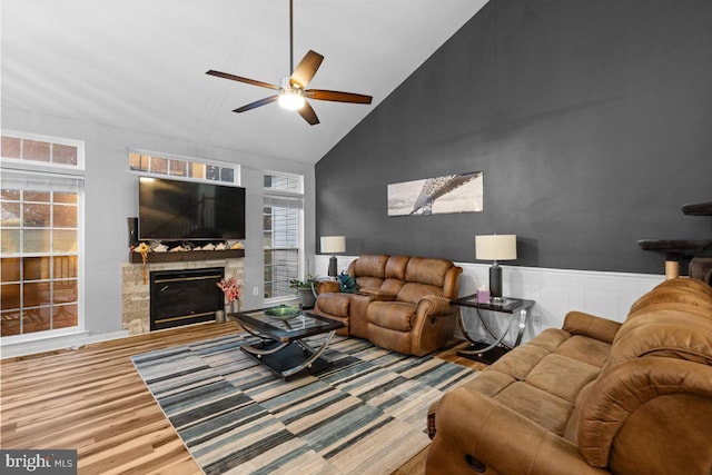 living room with ceiling fan, plenty of natural light, high vaulted ceiling, and wood-type flooring