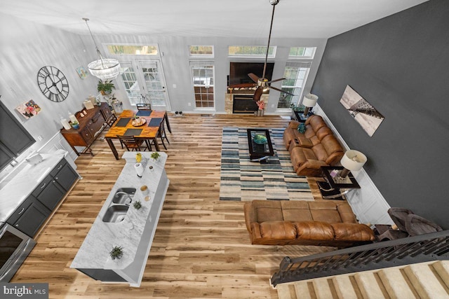 living room featuring sink, ceiling fan, and light hardwood / wood-style flooring