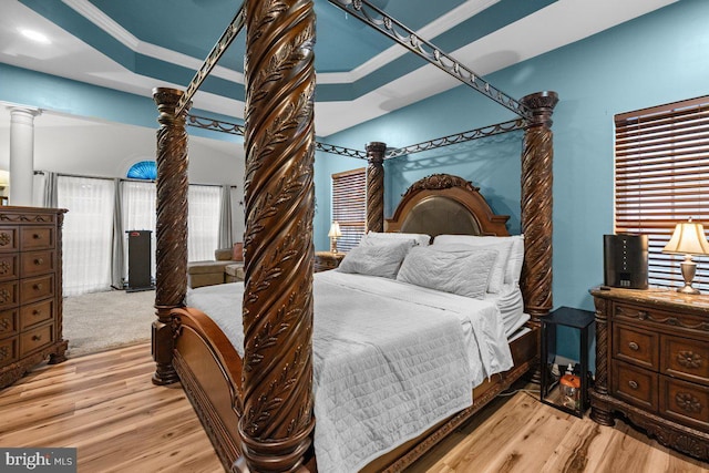 bedroom with ornamental molding, light hardwood / wood-style flooring, and decorative columns