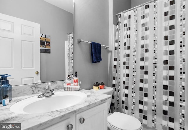 bathroom featuring vanity, curtained shower, and toilet