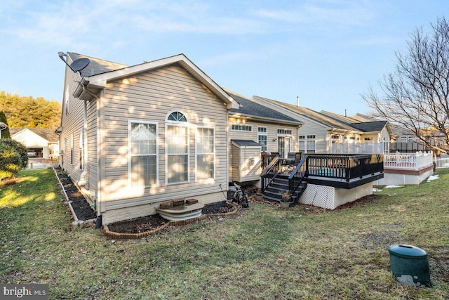 rear view of house featuring a yard and a deck