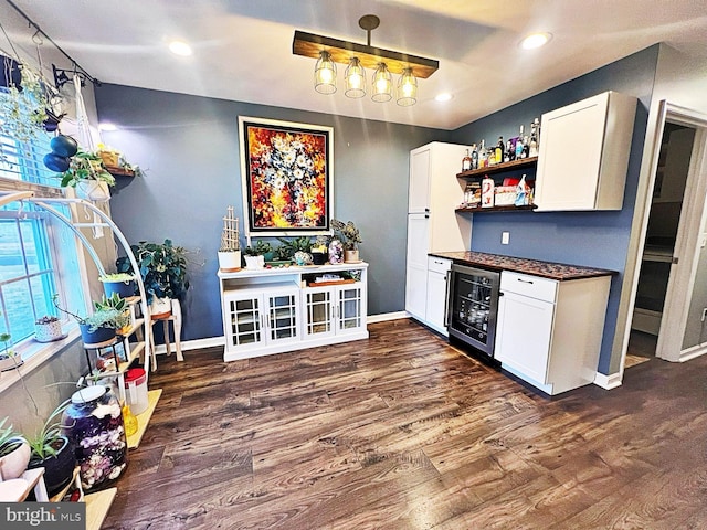 bar with white cabinets, dark hardwood / wood-style floors, and beverage cooler