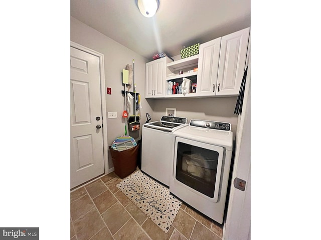 laundry area featuring washer and clothes dryer and cabinets