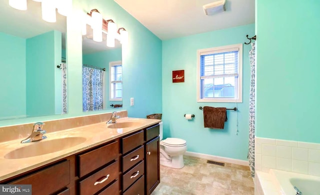 bathroom featuring vanity, plenty of natural light, toilet, and a bathing tub