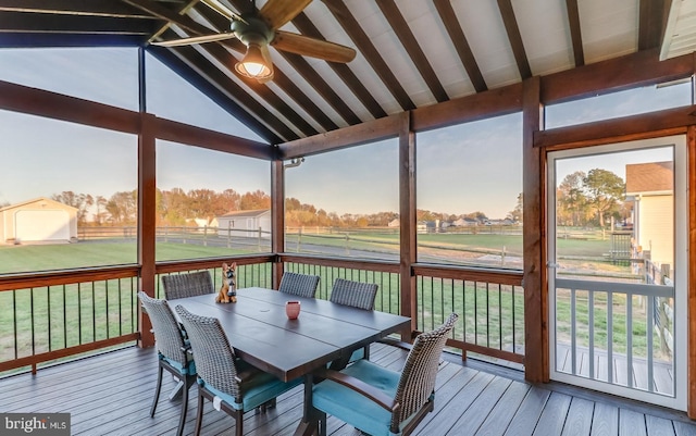 sunroom with lofted ceiling with beams and ceiling fan