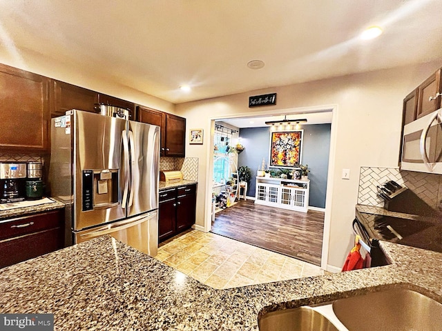 kitchen with stone counters, tasteful backsplash, and appliances with stainless steel finishes