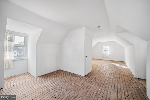 additional living space with lofted ceiling, light hardwood / wood-style flooring, and plenty of natural light