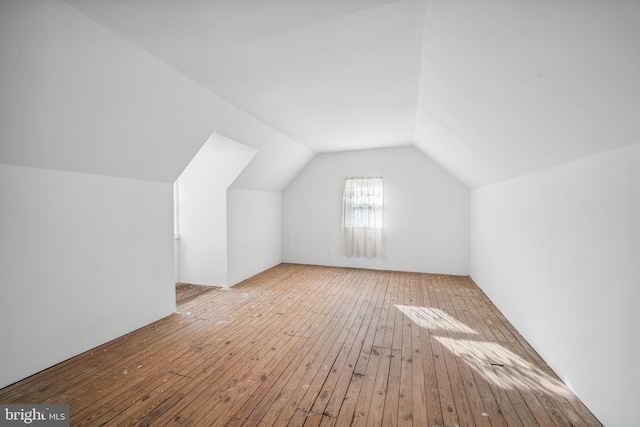 bonus room featuring lofted ceiling and light hardwood / wood-style flooring