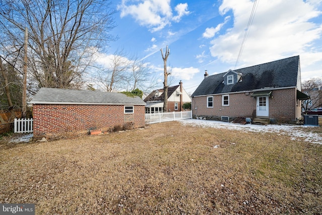 rear view of house with cooling unit and a yard