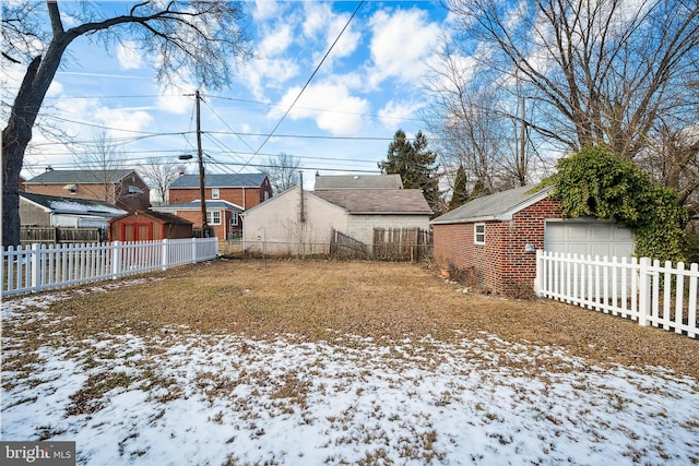 yard layered in snow featuring a garage and an outdoor structure