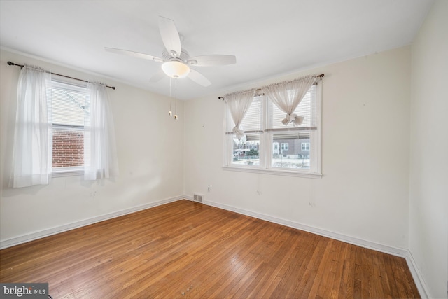 spare room with hardwood / wood-style floors, plenty of natural light, and ceiling fan