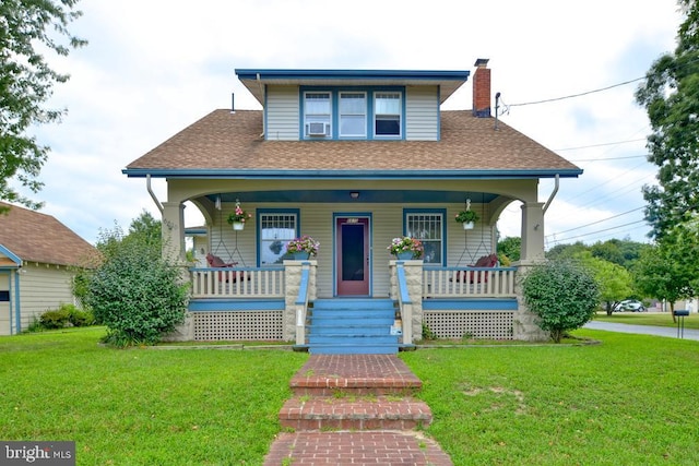 bungalow with covered porch and a front yard