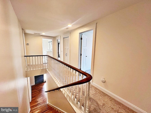 stairway featuring visible vents, baseboards, wood finished floors, and recessed lighting