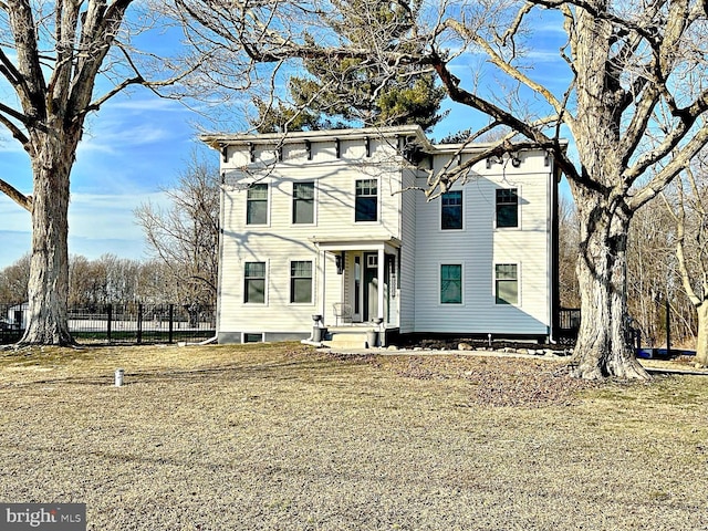 italianate-style house featuring fence and a front yard