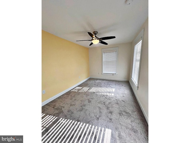 empty room featuring carpet flooring, ceiling fan, and baseboards