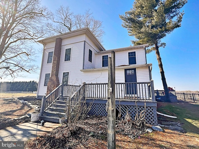 rear view of house featuring stairway and a wooden deck